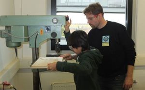 Arbeiten an der Ständerbohrmaschine durch Schülerinnen und Schüler der Mittelschule.